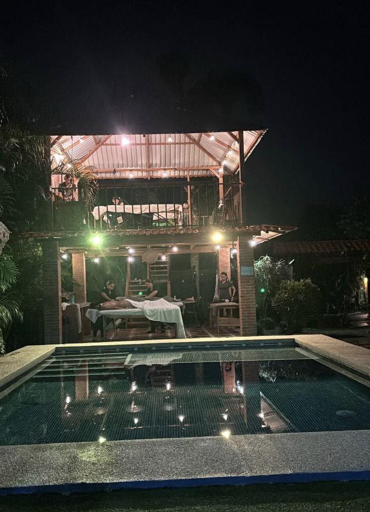 Camillas de masaje junto a la piscina, vista nocturna de Oasis Spa